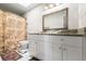 Well-lit bathroom with a large mirror, granite countertops, and a shower with a patterned curtain at 9814 Piney Point Cir, Orlando, FL 32825