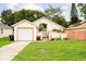 Charming single-story home with attached garage, vibrant landscaping and a well-manicured lawn at 9814 Piney Point Cir, Orlando, FL 32825