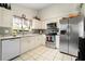 Efficient kitchen with white cabinetry, stainless steel appliances, and tiled floor at 9814 Piney Point Cir, Orlando, FL 32825