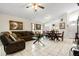 Bright living room with tiled floors and comfortable brown sofa. Open floorplan leads to the dining area at 9814 Piney Point Cir, Orlando, FL 32825