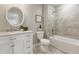 Well-lit bathroom with tub, shower, grey tiling, and a white vanity with marble countertop at 1031 Morningside Dr, Eustis, FL 32726