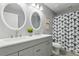 Modern bathroom featuring double sinks, round mirrors, and a shower-tub combo at 1031 Morningside Dr, Eustis, FL 32726