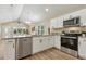 Open kitchen view with stainless steel appliances, granite countertops, and hardwood floors at 1031 Morningside Dr, Eustis, FL 32726
