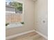 Bright laundry room featuring a large window offering natural light and wood-look vinyl flooring at 1031 Morningside Dr, Eustis, FL 32726