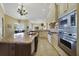 Bright kitchen showcases stainless steel appliances, granite counters, and seamless flow to other rooms at 12663 Hawkstone Dr, Windermere, FL 34786