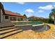 Backyard pool featuring a waterfall, tile, and brick pavers, with manicured lawns and an adjacent home at 12663 Hawkstone Dr, Windermere, FL 34786