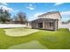 Expansive backyard with a custom putting green, screened-in patio, and lush landscaping at 13519 Bicton Ln, Windermere, FL 34786
