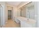 Upscale bathroom featuring double sinks, quartz counters, and a glass-enclosed shower for convenience at 13519 Bicton Ln, Windermere, FL 34786