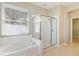 Well-lit bathroom featuring a soaking tub, glass enclosed shower, and a bright sunny window at 13519 Bicton Ln, Windermere, FL 34786