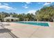 Community pool with a clubhouse, lounge chairs, and surrounded by mature trees at 13519 Bicton Ln, Windermere, FL 34786