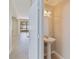 Elegant powder room showcasing a pedestal sink, oval mirror, and stylish lighting fixtures at 13519 Bicton Ln, Windermere, FL 34786