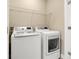 Laundry room with side-by-side white washer and dryer, and wire shelving at 13618 Heaney Ave, Orlando, FL 32827