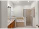 Bright bathroom featuring double sinks, a soaking tub, and a separate glass shower at 13768 Bluebird Pond Rd, Windermere, FL 34786