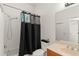Bright bathroom featuring a shower with a black curtain, a neutral sink, and a large mirror at 13768 Bluebird Pond Rd, Windermere, FL 34786