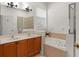 Well-lit bathroom with double sinks, a soaking tub with tile surround, and a glass shower at 13768 Bluebird Pond Rd, Windermere, FL 34786