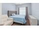 Serene bedroom with soft blue walls, plush carpeting, and a comfortable upholstered bed at 13768 Bluebird Pond Rd, Windermere, FL 34786