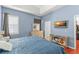 Blue bedroom featuring wood floors, a large window, and a wall-mounted TV at 13768 Bluebird Pond Rd, Windermere, FL 34786