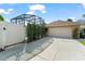 Garage with a driveway and a white gate leading to the screened-in pool at 13768 Bluebird Pond Rd, Windermere, FL 34786