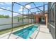A private pool is surrounded by a screen enclosure and a white fence at 13768 Bluebird Pond Rd, Windermere, FL 34786
