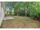 View of the backyard features mature trees, lush foliage, and a cozy patio area at 14565 Lycastle Cir, Orlando, FL 32826