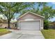 Inviting home exterior featuring a well-manicured lawn and a spacious two-car garage at 14565 Lycastle Cir, Orlando, FL 32826