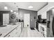 Bright kitchen features white cabinets, granite counters, stainless steel appliances, and tiled floors at 14565 Lycastle Cir, Orlando, FL 32826