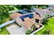 Expansive view of the home featuring a pool with enclosure and solar panels at 14723 Pine Cone Trl, Clermont, FL 34711