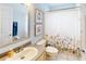Bathroom includes a floral shower curtain, a vanity with a sink, and tiled flooring at 14723 Pine Cone Trl, Clermont, FL 34711