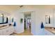 Bathroom with dual vanities, wood-look tile flooring and a walk-in closet at 14723 Pine Cone Trl, Clermont, FL 34711