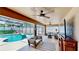 An inviting covered patio with ceiling fans, plush seating, and a view of the sparkling pool and spa at 14723 Pine Cone Trl, Clermont, FL 34711