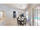 Bright dining area with a round table, modern chairs, and access to the outdoor pool area at 14723 Pine Cone Trl, Clermont, FL 34711
