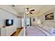 This bedroom has hardwood floors, a ceiling fan, and a view to the pool at 14723 Pine Cone Trl, Clermont, FL 34711