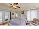 Primary bedroom with a four-poster bed, ceiling fan, and access to the outdoors at 14723 Pine Cone Trl, Clermont, FL 34711