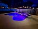A relaxing pool with colorful lights is beautifully set against a dark sky, highlighting the attached spa at 14723 Pine Cone Trl, Clermont, FL 34711