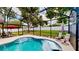 A screened-in pool in the backyard has lounge chairs at 14723 Pine Cone Trl, Clermont, FL 34711