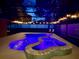 Inviting pool with spa featuring an enclosure and string lights, perfect for evening relaxation at 14723 Pine Cone Trl, Clermont, FL 34711