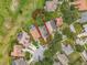 Aerial view of a property with a defined lot, surrounded by lush greenery and neighborhood at 16631 Champions Ct, Clermont, FL 34711