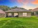 The backyard features lush green grass, a well-maintained lawn, and a screened-in patio at 16631 Champions Ct, Clermont, FL 34711