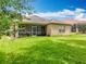 Expansive backyard features lush grass and a screened-in patio, perfect for outdoor living at 16631 Champions Ct, Clermont, FL 34711