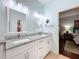 Bathroom with double sinks, granite counters, and a view to bedroom at 16631 Champions Ct, Clermont, FL 34711