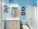 Light blue bathroom with white vanity, toilet, tub, and nautical decor at 16631 Champions Ct, Clermont, FL 34711