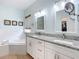 Bathroom featuring a soaker tub, a window, and granite counters at 16631 Champions Ct, Clermont, FL 34711