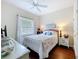Bright bedroom with hardwood floors, a ceiling fan, and a serene window view at 16631 Champions Ct, Clermont, FL 34711