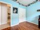 Bedroom with hardwood floors, blue walls, white trim, and closet space at 16631 Champions Ct, Clermont, FL 34711