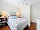 Cozy bedroom featuring hardwood floors, coastal decor, and a ceiling fan at 16631 Champions Ct, Clermont, FL 34711