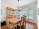 Elegant dining room featuring a wooden table, hutch, and natural light from a large window at 16631 Champions Ct, Clermont, FL 34711