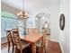 Inviting dining room with hardwood floors, modern chandelier, and sunlit windows at 16631 Champions Ct, Clermont, FL 34711