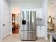 Stainless steel refrigerator with white cabinets and granite countertops in an open kitchen layout at 16631 Champions Ct, Clermont, FL 34711