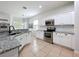 Bright kitchen with white cabinetry, granite countertops, and stainless steel appliances at 16631 Champions Ct, Clermont, FL 34711