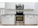 Well-lit kitchen with white cabinets, subway tile backsplash, and stainless steel range at 16631 Champions Ct, Clermont, FL 34711